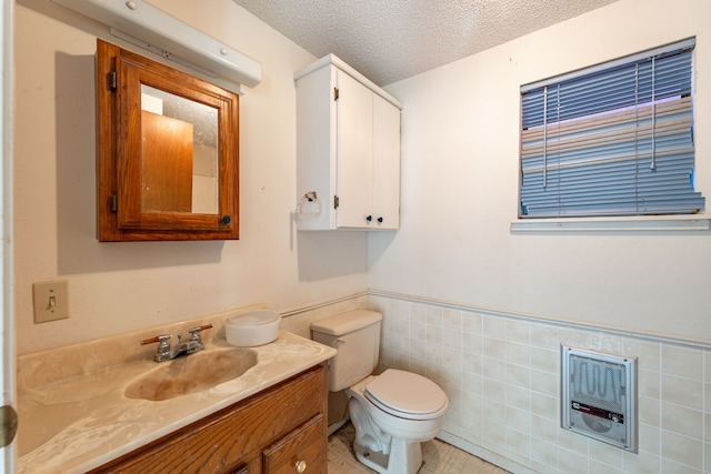 bathroom featuring vanity, tile walls, a textured ceiling, and toilet