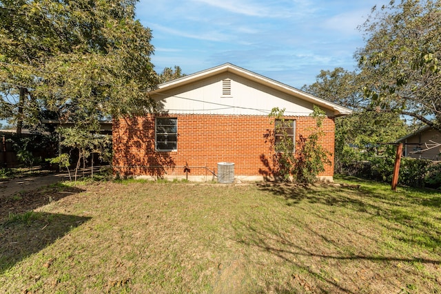 back of house with a yard and central air condition unit