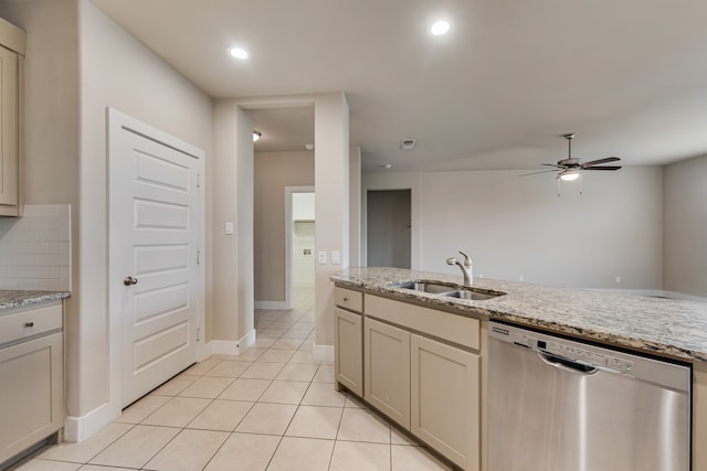 kitchen featuring cream cabinets, light stone counters, light tile patterned flooring, sink, and dishwasher