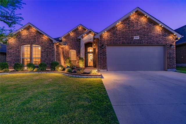 view of front of property featuring a lawn and a garage