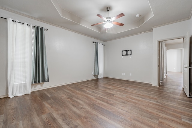 spare room with crown molding, hardwood / wood-style flooring, ceiling fan, and a raised ceiling