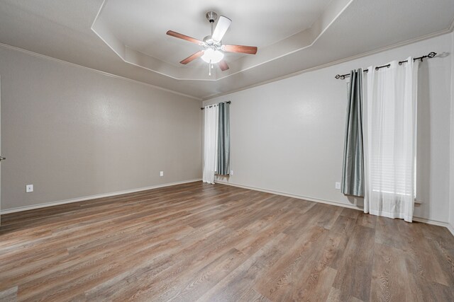 2216 Rosalinda Pass, Fort Worth, TX 76131 - empty room featuring a tray ceiling, wood finished floors, a ceiling fan, baseboards, and ornamental molding