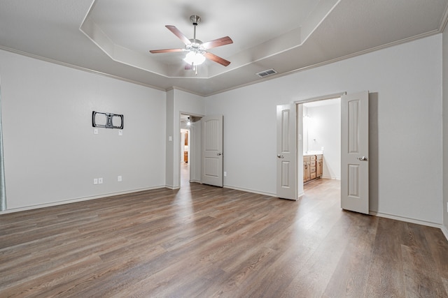 unfurnished bedroom with hardwood / wood-style flooring, ceiling fan, a raised ceiling, and ornamental molding