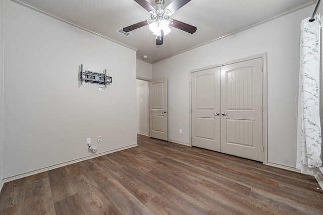 unfurnished bedroom with hardwood / wood-style flooring, ceiling fan, a closet, and ornamental molding