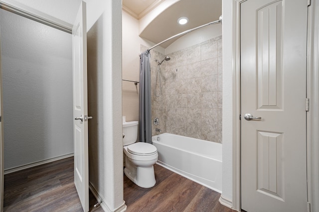 bathroom featuring toilet, hardwood / wood-style flooring, ornamental molding, and shower / bathtub combination with curtain