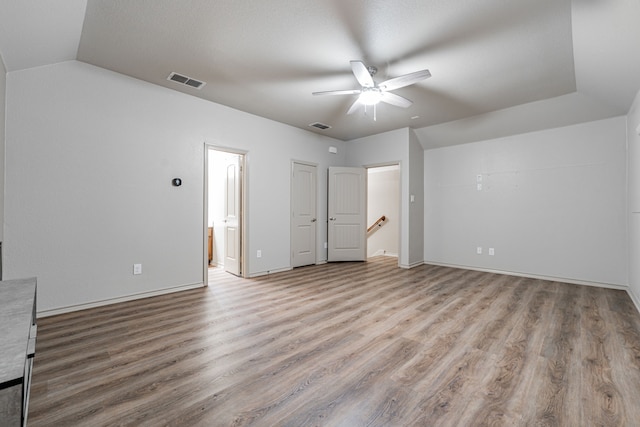 unfurnished bedroom with light hardwood / wood-style floors, lofted ceiling, ceiling fan, and ensuite bath