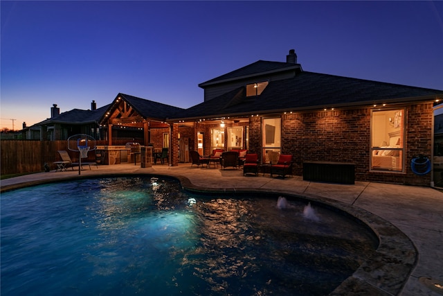 pool at dusk with a patio