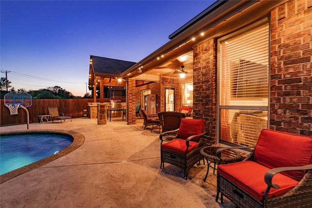 pool at dusk with a patio area