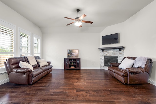 living room featuring a stone fireplace, dark wood-type flooring, ceiling fan, and lofted ceiling