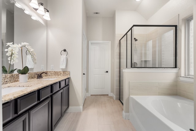 bathroom featuring tile patterned flooring, lofted ceiling, independent shower and bath, and vanity