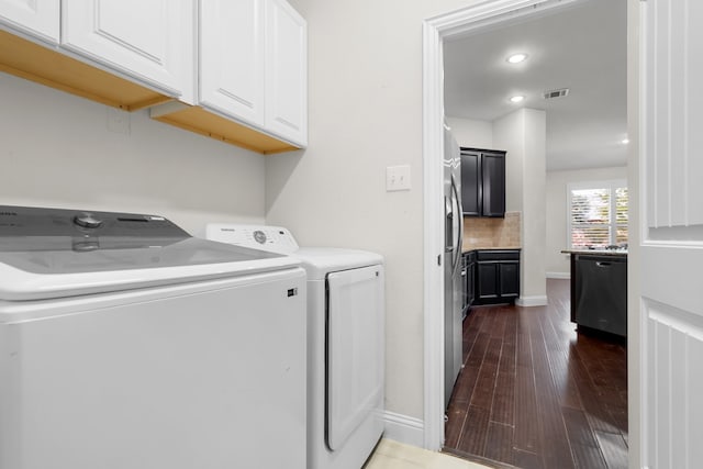 laundry area with cabinets, washing machine and dryer, and dark wood-type flooring