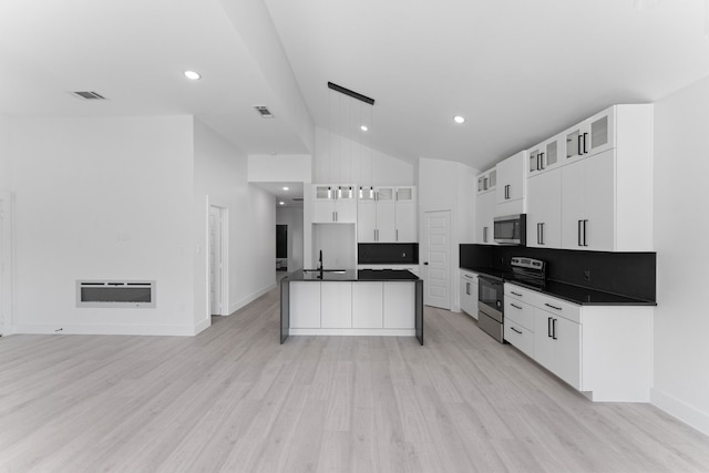 kitchen with sink, white cabinetry, hanging light fixtures, stainless steel appliances, and light hardwood / wood-style floors