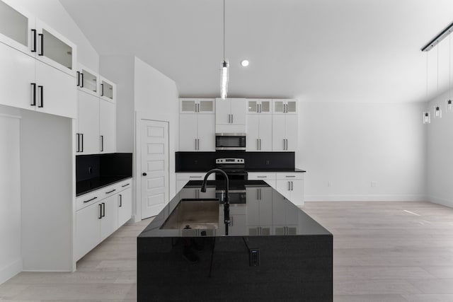 kitchen featuring hanging light fixtures, appliances with stainless steel finishes, a center island with sink, and white cabinets