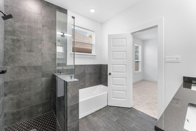 bathroom featuring shower with separate bathtub