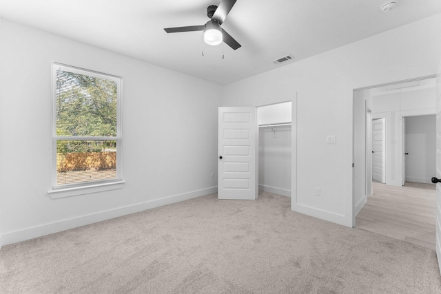 unfurnished bedroom featuring ceiling fan, light colored carpet, and a closet