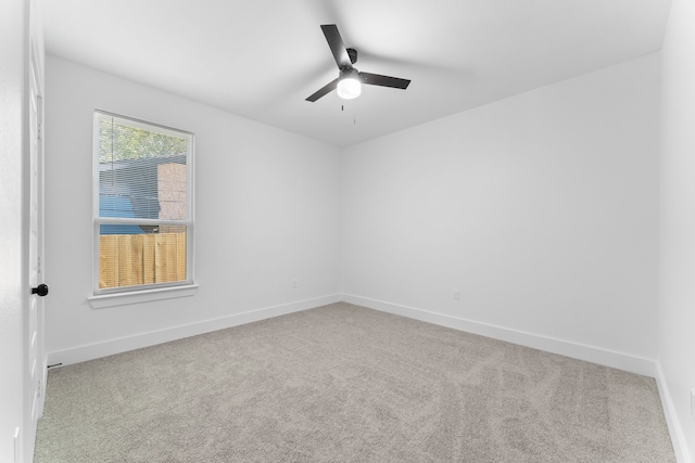 carpeted spare room with ceiling fan