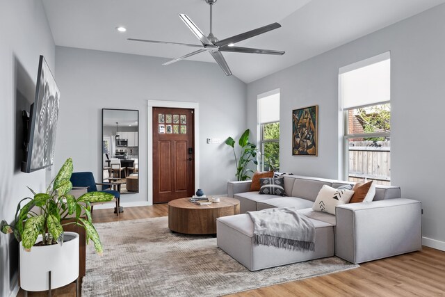 living room with vaulted ceiling, hardwood / wood-style flooring, and ceiling fan