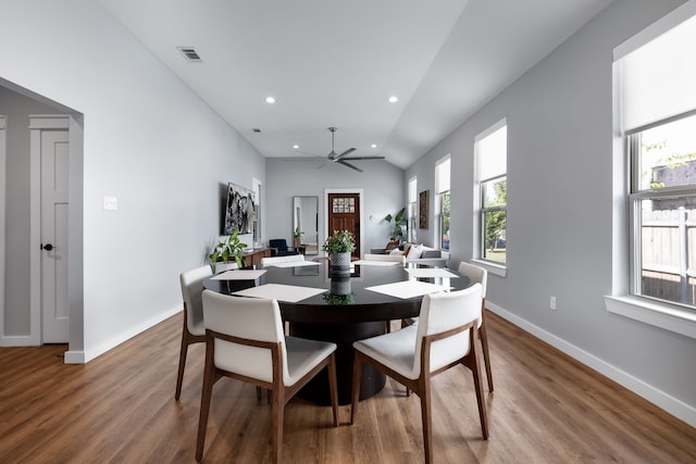 dining space with hardwood / wood-style floors, ceiling fan, and vaulted ceiling