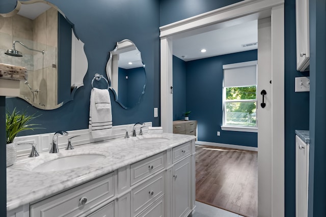 bathroom featuring walk in shower, vanity, and wood-type flooring