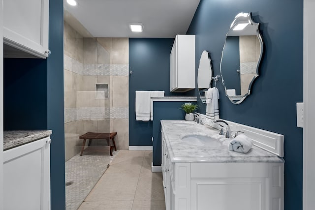 bathroom featuring a tile shower, vanity, and tile patterned floors