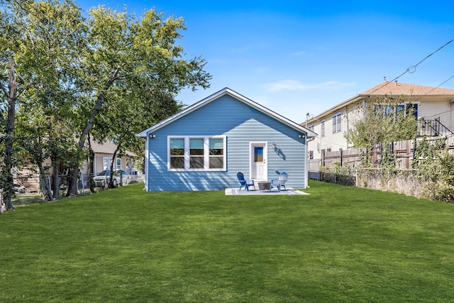 rear view of house with a patio and a lawn