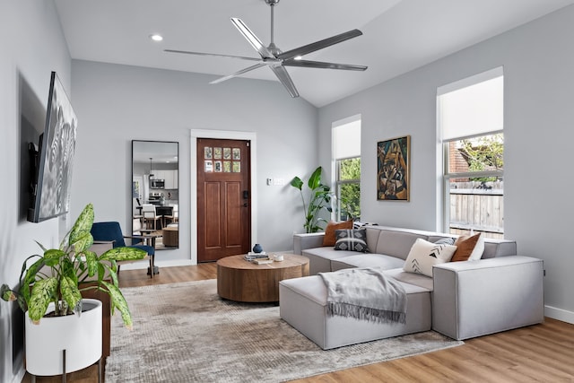 living room featuring ceiling fan, light hardwood / wood-style flooring, and lofted ceiling