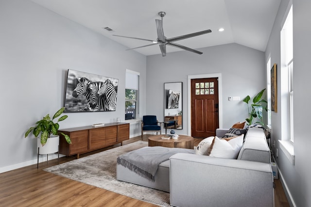 living room with a wealth of natural light, hardwood / wood-style floors, lofted ceiling, and ceiling fan