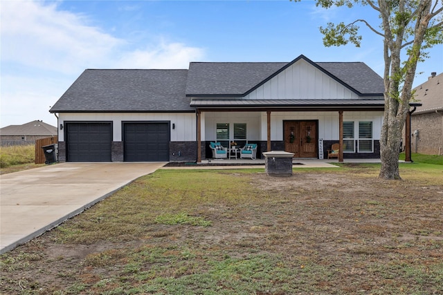 view of front facade with covered porch, french doors, a garage, and a front yard