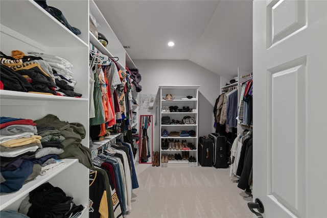 walk in closet featuring light carpet and vaulted ceiling