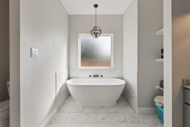 bathroom featuring a notable chandelier, a tub to relax in, toilet, vanity, and tile walls