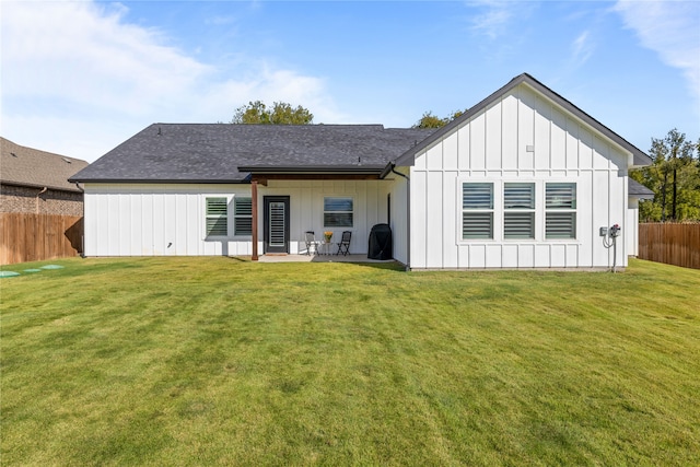 rear view of property featuring a lawn and a patio