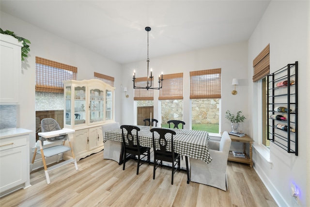 dining space with light hardwood / wood-style flooring and a notable chandelier