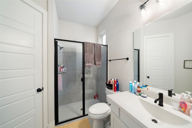 bathroom featuring toilet, vanity, tile patterned floors, and a shower with shower door