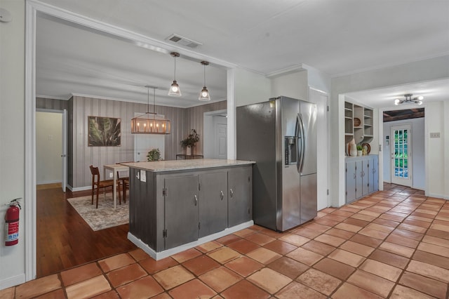 kitchen with pendant lighting, built in features, crown molding, and stainless steel fridge with ice dispenser