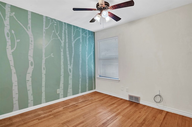 empty room with hardwood / wood-style floors and ceiling fan