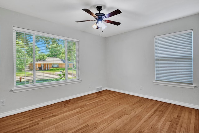 spare room with light wood-type flooring, plenty of natural light, and ceiling fan