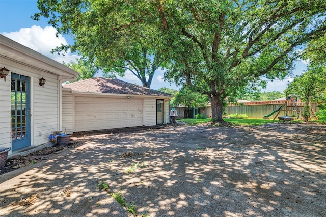 view of yard featuring a playground and a garage