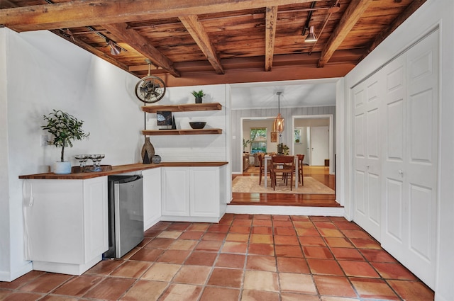 kitchen featuring beamed ceiling, stainless steel refrigerator, wood ceiling, and pendant lighting