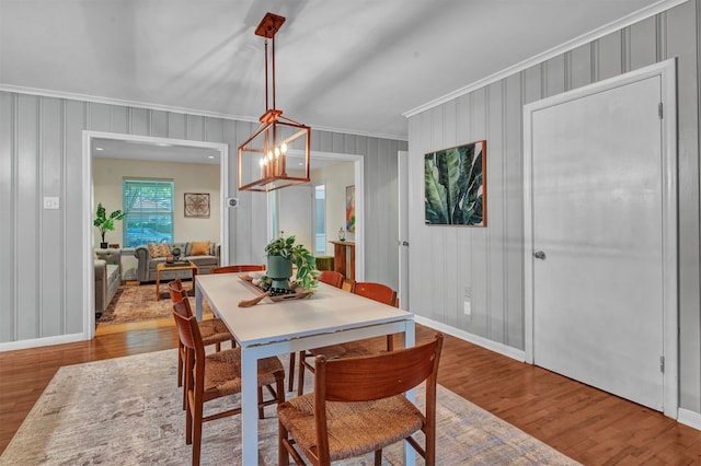 dining area featuring wood-type flooring and ornamental molding