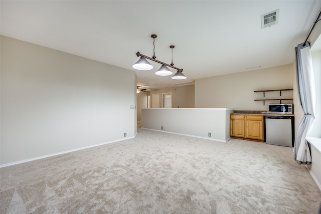 kitchen with pendant lighting, appliances with stainless steel finishes, light colored carpet, and ceiling fan