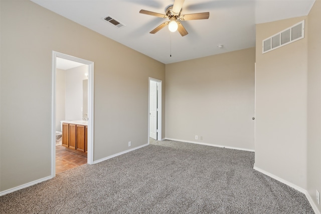 unfurnished bedroom with ensuite bath, ceiling fan, and light colored carpet