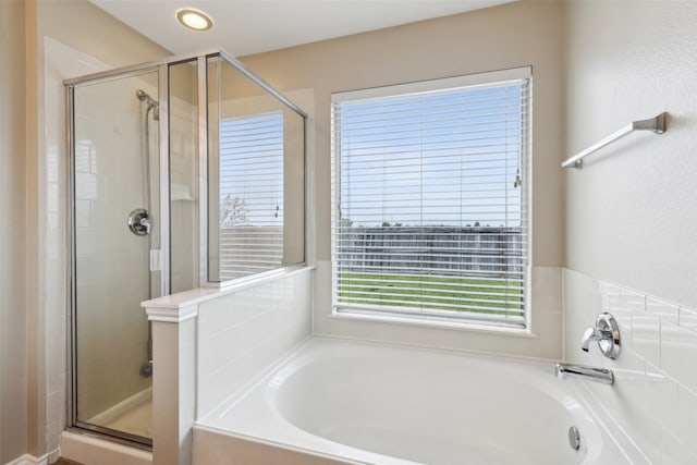 bathroom featuring shower with separate bathtub