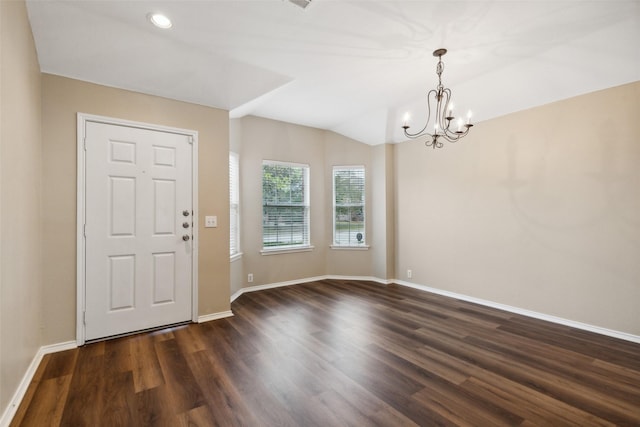 foyer entrance with lofted ceiling, dark hardwood / wood-style flooring, and a notable chandelier