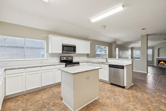 kitchen with white cabinets, a center island, sink, and stainless steel appliances