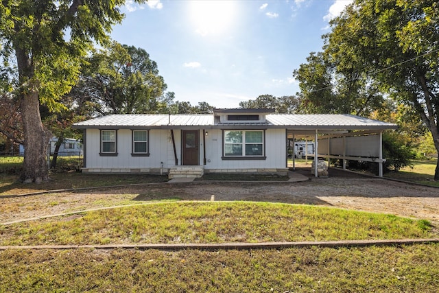 view of front of house with a front yard and a carport