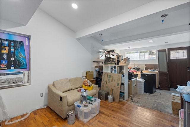 living room with cooling unit, light hardwood / wood-style floors, and beam ceiling