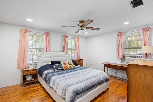 bedroom featuring light wood-type flooring, multiple windows, and ceiling fan