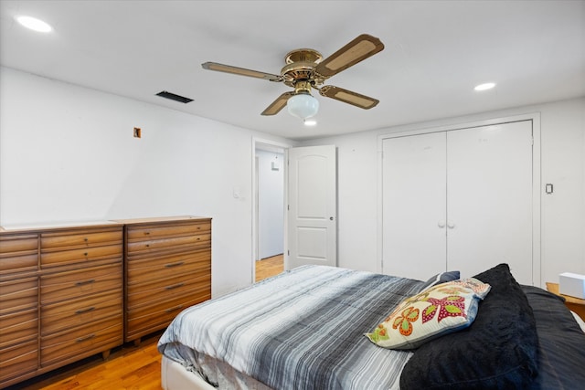 bedroom featuring ceiling fan, a closet, and light wood-type flooring