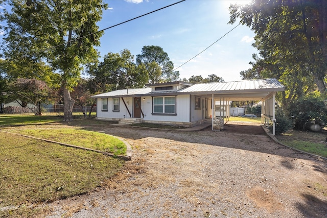 view of front of home with a carport and a front lawn