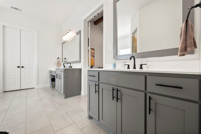 bathroom featuring two vanities, visible vents, a sink, tile patterned flooring, and baseboards